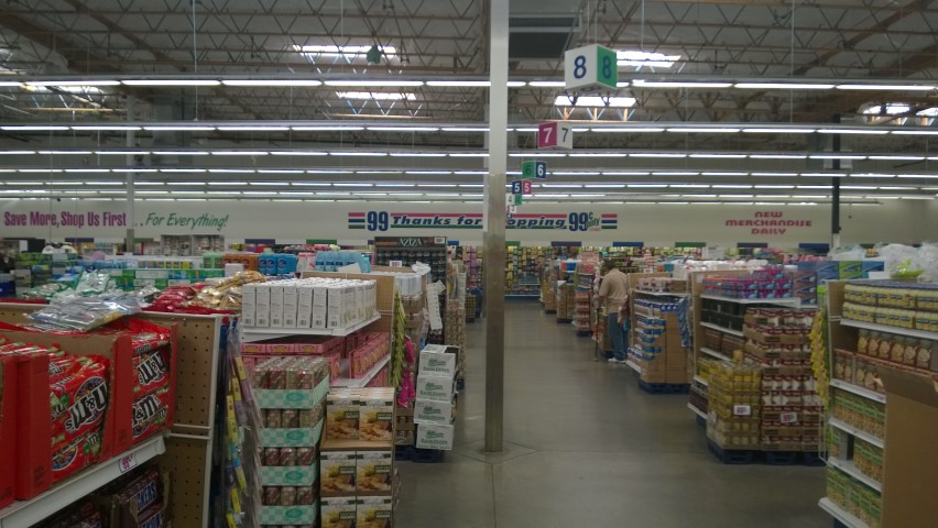 Inside the 99 cent supermarket, with fruit and veg, and a frozen food section.